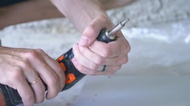 bir adam bir atölyede mobilya toplar. 4k, ağır çekim. Bağ ve mobilya ahşap pimleri üzerine montajı