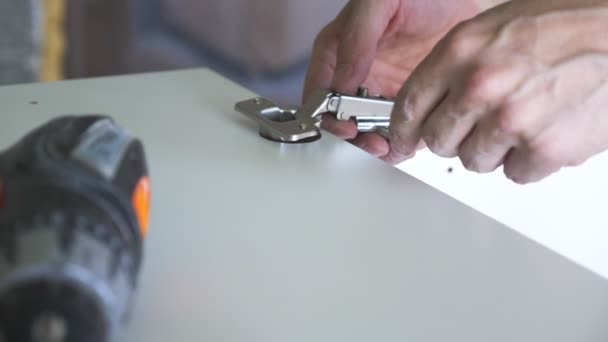 Een man verzamelt meubilair in een workshop. 4k, slow-motion. Lijmen en assemblage van meubilair op de houten pinnen — Stockvideo