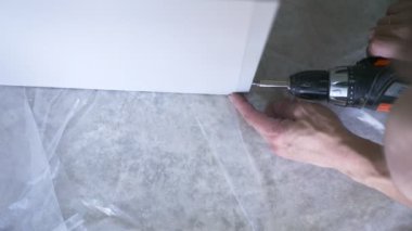 bir adam bir atölyede mobilya toplar. 4k, ağır çekim. Bağ ve mobilya ahşap pimleri üzerine montajı