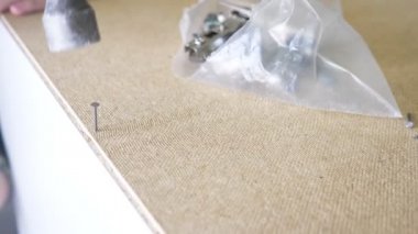 bir adam bir atölyede mobilya toplar. 4k, ağır çekim. Bağ ve mobilya ahşap pimleri üzerine montajı