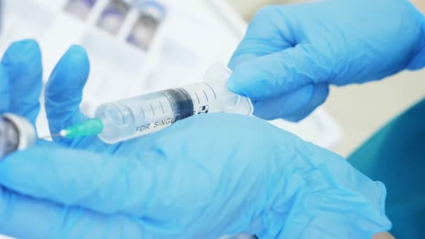 Um médico ou cientista num laboratório segurando uma seringa com vacinas líquidas. Conceito: doenças, cuidados médicos, ciência, anestesia. 4k — Vídeo de Stock