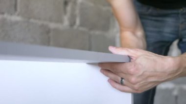 bir adam bir atölyede mobilya toplar. 4k, ağır çekim. Bağ ve mobilya ahşap pimleri üzerine montajı