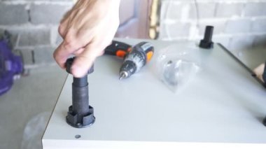 bir adam bir atölyede mobilya toplar. 4k, ağır çekim. Bağ ve mobilya ahşap pimleri üzerine montajı