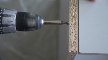 bir adam bir atölyede mobilya toplar. 4k, ağır çekim. Bağ ve mobilya ahşap pimleri üzerine montajı