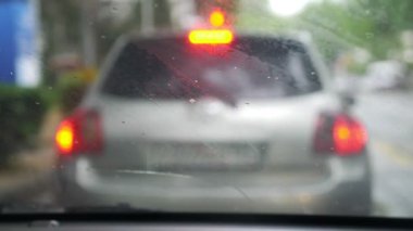 Yağmur yolda araba araba ön cam zor sürüş koşullarında splatters. trafik sıkışıklığı. Silecek Motoru Varyak. 4k, ağır çekim