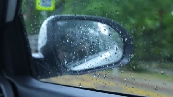 Yağmurda görünümünden arabanın içindeki sürücü, araba aynaya bakın. 4k, ağır çekim — Stok video