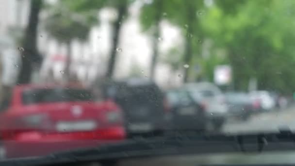 Car on road Rain splatters car windshield during difficult driving conditions. traffic jam. Windscreen wiper. 4k, slow motion — Stock Video