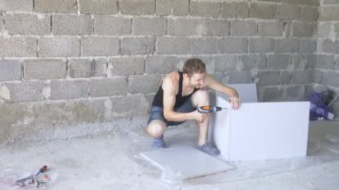bir adam bir atölyede mobilya toplar. 4k, ağır çekim. Bağ ve mobilya ahşap pimleri üzerine montajı