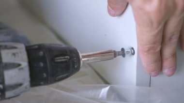bir adam bir atölyede mobilya toplar. 4k, ağır çekim. Bağ ve mobilya ahşap pimleri üzerine montajı