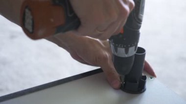 bir adam bir atölyede mobilya toplar. 4k, ağır çekim. Bağ ve mobilya ahşap pimleri üzerine montajı