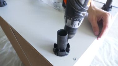 bir adam bir atölyede mobilya toplar. 4k, ağır çekim. Bağ ve mobilya ahşap pimleri üzerine montajı