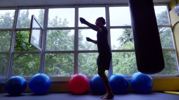 Thai boksen opleiding Europese jongeman in de sportschool. 4k, slow-motion. silhouet. warming-up, springtouw — Stockvideo