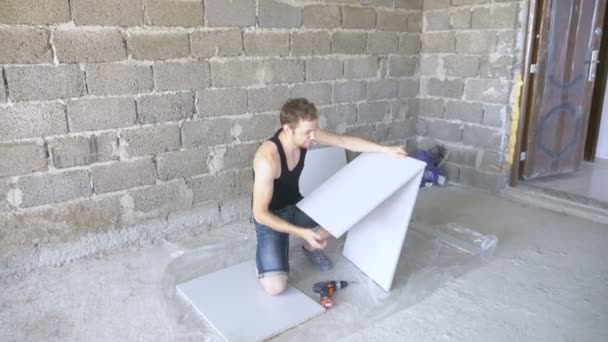 Un hombre recoge muebles en un taller. 4k, cámara lenta. Fijación y montaje de muebles en los pasadores de madera — Vídeos de Stock