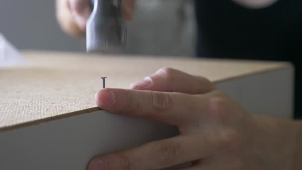 Un homme recueille des meubles dans un atelier. 4k, au ralenti. Collage et assemblage de meubles sur les broches en bois — Video