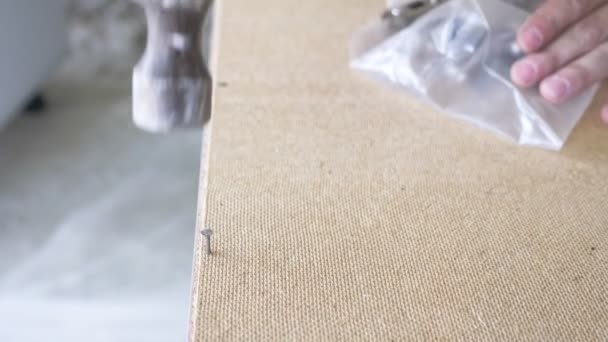 Een man verzamelt meubilair in een workshop. 4k, slow-motion. Lijmen en assemblage van meubilair op de houten pinnen — Stockvideo