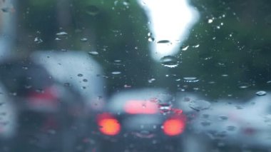 Yağmur yolda araba araba ön cam zor sürüş koşullarında splatters. trafik sıkışıklığı. Silecek Motoru Varyak. 4k, ağır çekim