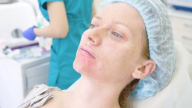 Hijyenik şapkalı bir kadın hasta yordamı doktor ofisinde bekliyor. yakın çekim. 4k