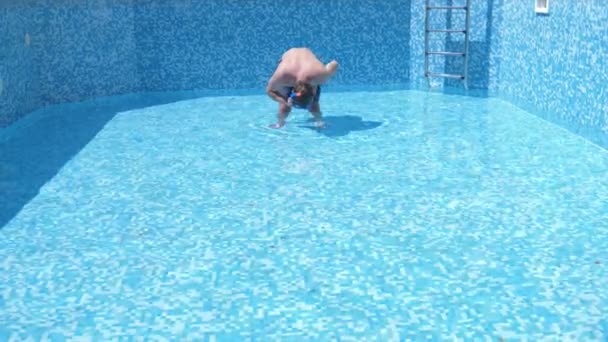 Un jeune homme drôle monte dans une piscine vide avec un masque de plongée et tuba. 4k. humour . — Video