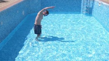 boş bir yüzme havuzu Şnorkelle Dalma maskesi ve şnorkel içine komik bir genç adam tırmanıyor. 4 k. mizah.