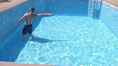 boş bir yüzme havuzu Şnorkelle Dalma maskesi ve şnorkel içine komik bir genç adam tırmanıyor. 4 k. mizah.