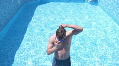 boş bir yüzme havuzu Şnorkelle Dalma maskesi ve şnorkel içine komik bir genç adam tırmanıyor. 4 k. mizah.