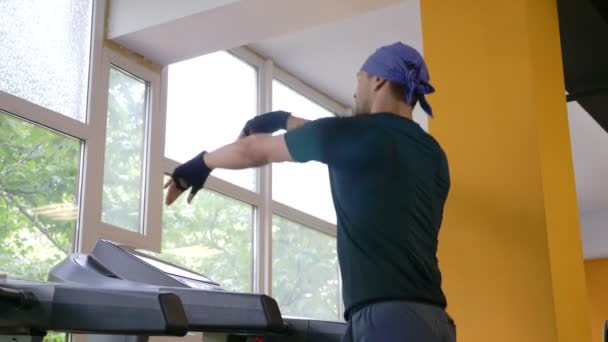 A cute guy runs on a treadmill in the gym. 4k, slow motion — Stock Video