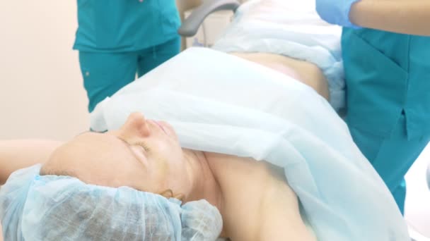 Un médico dermatólogo-cosmetólogo inyecta lipolita con una jeringa en los pliegues de grasa en el estómago de las mujeres de la paciente. 4k . — Vídeos de Stock