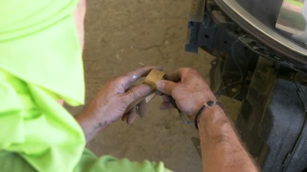 De près. des mains des mécaniciens, qui enlève le pare-chocs de la voiture, il répare la voiture. 4k — Video