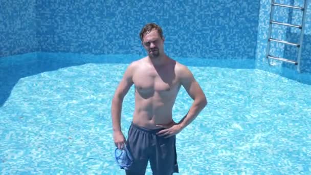 Um cara engraçado jovem sobe em uma piscina vazia com uma máscara de snorkel e snorkel. 4K. humor . — Vídeo de Stock