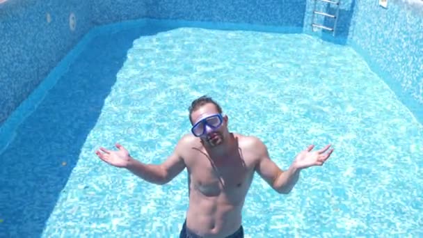 Молодий смішний хлопець піднімається в порожній басейн зі снорклінговою маскою і сноркелем. 4k. гумор . — стокове відео