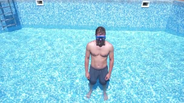 Boş bir yüzme havuzu Şnorkelle Dalma maskesi ve şnorkel içine komik bir genç adam tırmanıyor. 4 k. mizah. — Stok video