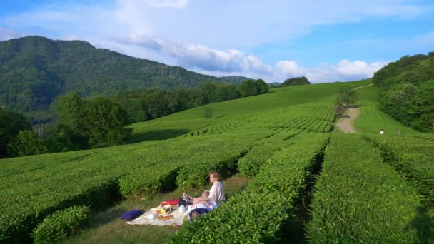 Güzel bir çift erkek ve kadın arasında bir çay plantasyon bir açıklıkta romantik tarih. seyahat, eğlence kavramı. Yaşam tarzı. 4k. — Stok video