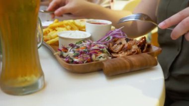 açık bir kafede yemek Yunan yemekleri, souvlaki ve bira bir çift. 4k, ağır çekim