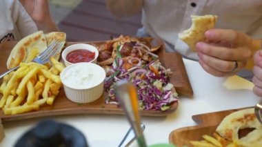 bir kadın bir açık hava Kafe Yunan yemekleri, souvlaki yiyor. Eller Close-up. 4k, ağır çekim