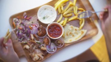 bir kadın bir açık hava Kafe Yunan yemekleri, souvlaki yiyor. Eller Close-up. 4k, ağır çekim