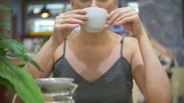 Kafedeki kadına Zencefil limon çay içiyor. şeffaf Çaydanlık, 4k, ağır çekim çekim