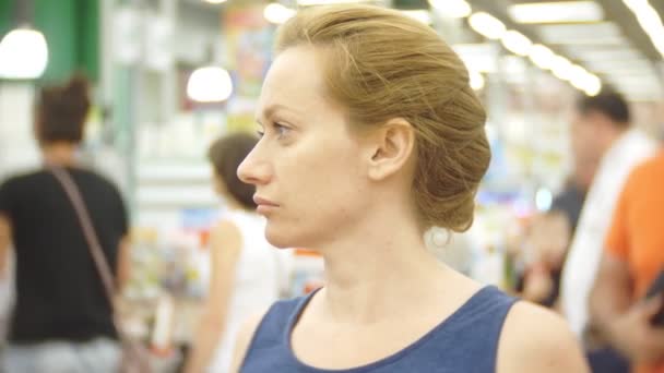 Жінка-покупець чекає в черзі в касі в торговому центрі. розмиття тла. 4k — стокове відео
