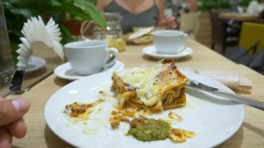 bir adam bir çatal ve bıçak ile bir restoranda lazanya yemek yer. yakın çekim. 4k, ağır çekim