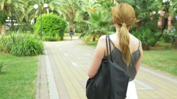 Egy profi fotós, fényképek a szépség, a trópusi park, egy nő egy gomb-ból egy szerkentyű prések között egy virágzó kert. 4k, lassú mozgás — Stock videók