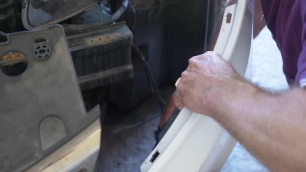 Закрывай. механика руки, который снимает бампер автомобиля, он ремонтирует машину. 4k — стоковое видео