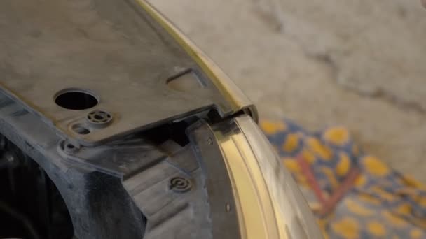 Close-up. van de handen van de mechanica, die de bumper van de auto verwijdert, herstelt hij de auto. 4k — Stockvideo