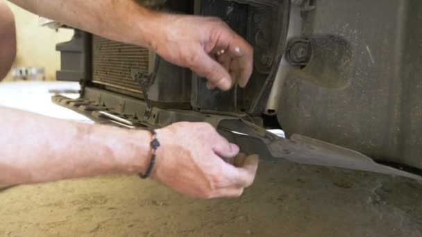 De près. des mains des mécaniciens, qui enlève le pare-chocs de la voiture, il répare la voiture. 4k — Video