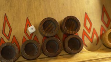 Ayrıntı ile iki zar tavla oyunun kapatın. İki zar haddeleme ve dama gemide hareket kadın ve erkek eller. Dinlenirken tavla oynayan genç insanlar. 4k, ağır çekim