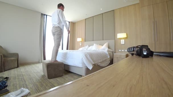 Счастливый человек падает на кровать, 4K, экшн-камера — стоковое видео