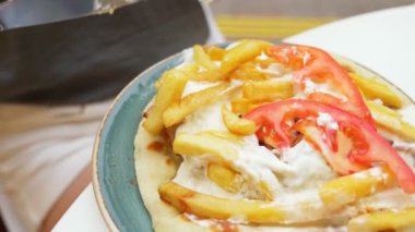 bir kadın bir açık hava Kafe Yunan yemekleri, souvlaki yiyor. Eller Close-up. 4k, ağır çekim