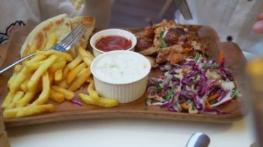 bir kadın bir açık hava Kafe Yunan yemekleri, souvlaki yiyor. Eller Close-up. 4k, ağır çekim