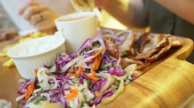 açık bir kafede yemek Yunan yemekleri, souvlaki ve bira bir çift. 4k, ağır çekim