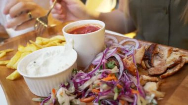 açık bir kafede yemek Yunan yemekleri, souvlaki ve bira bir çift. 4k, ağır çekim