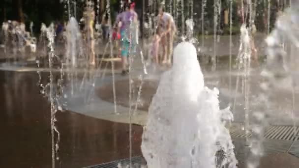 子供たちは、都市噴水の水の流れに遊ぶ。夏の南。4 k、スロー モーションぼかし — ストック動画
