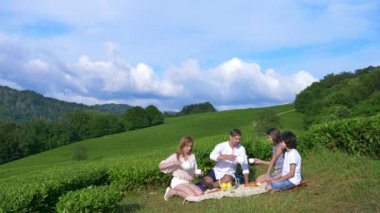 Aile piknik bir çay plantasyon arasında bir açıklıkta. seyahat, rekreasyon kavramı. yaşam tarzı. 4k.
